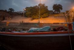 A man sleeping in a boat in Varanasi, India